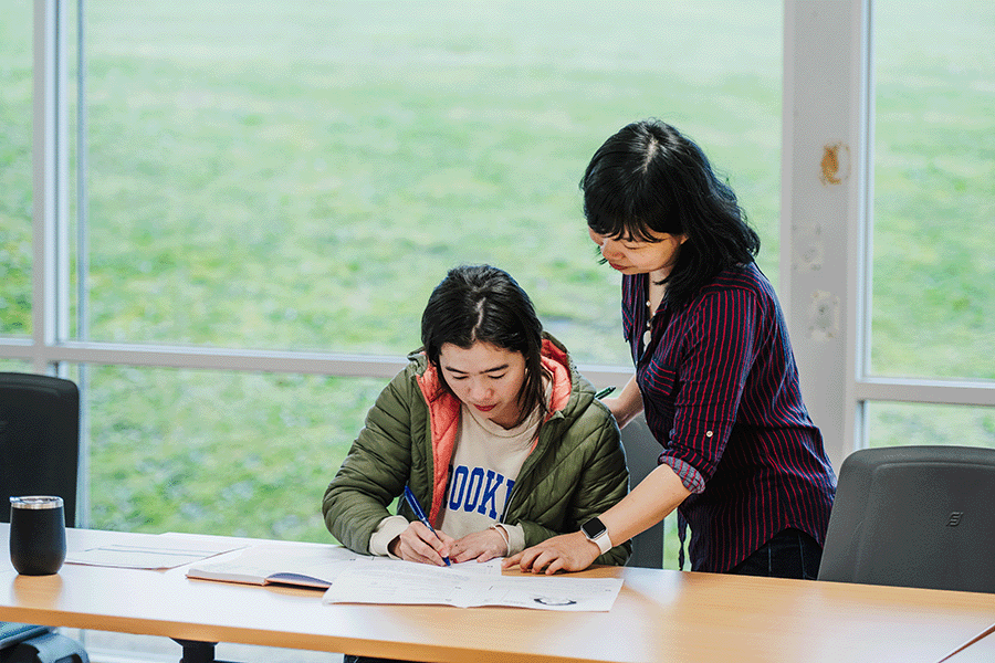 Tutor helping student in English class at Endeavour Hills Neighbourhood Centre