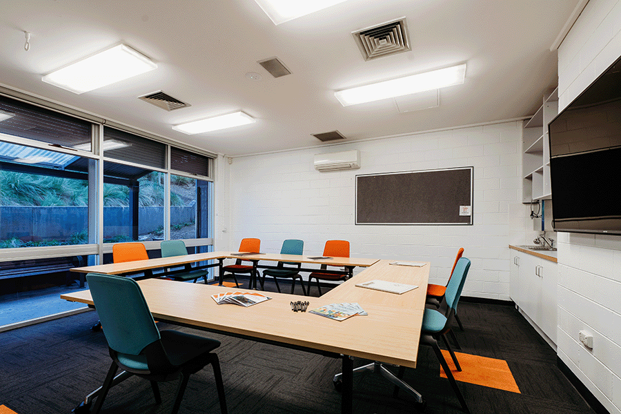 Light-filled meeting room inside Endeavour Hills Neighbourhood Centre equipped with tables and chairs