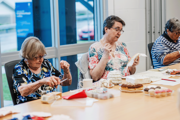 Group of women working individually on sewing projects while sitting together