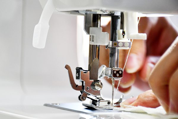 Close up of woman's hands sewing for charity